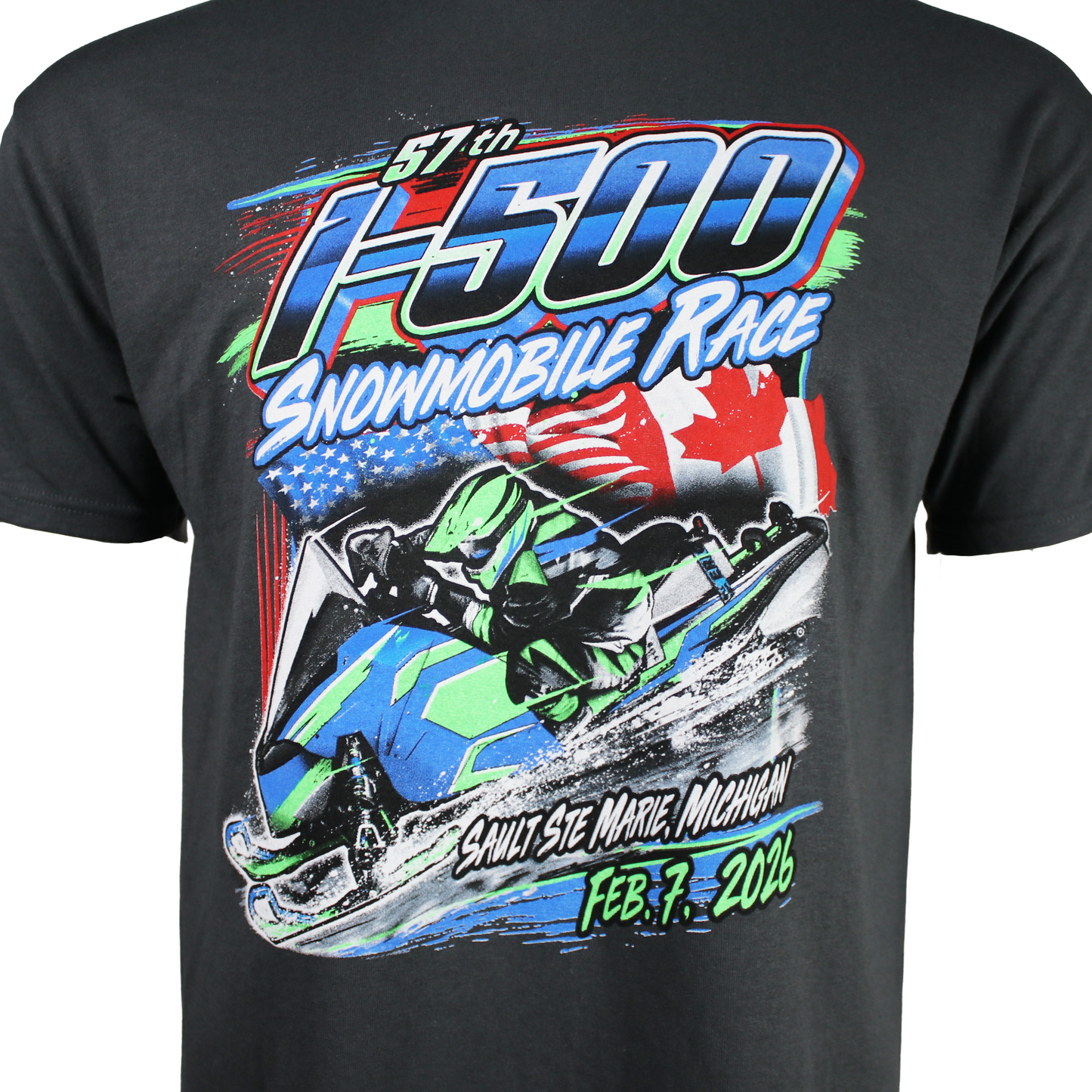 Close up of a dark grey t-shirt with a snowmobile race graphic on the front with the text 'I-500 snowmobile Race, Sault Ste. Marie, Michigan, February 7th, 2026'.